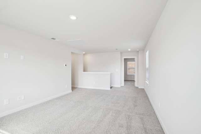 empty room with light carpet, baseboards, and recessed lighting