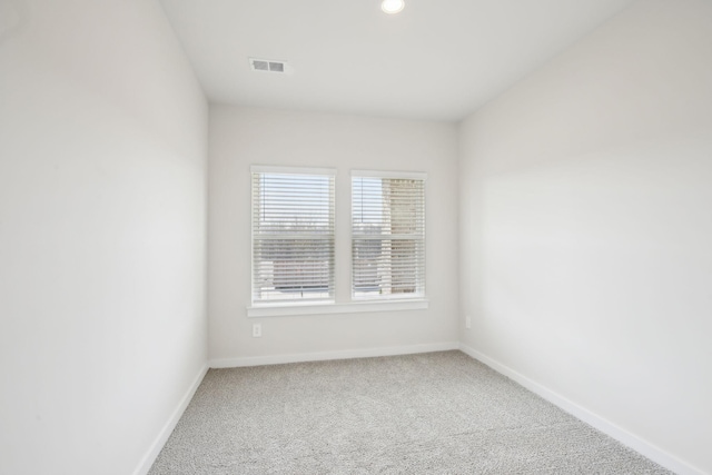 carpeted empty room featuring baseboards and visible vents