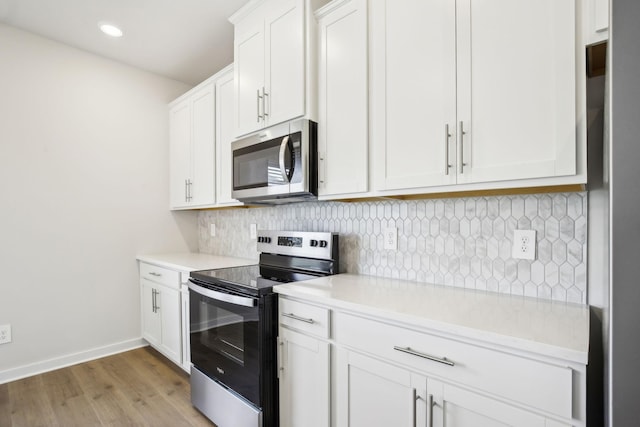 kitchen with stainless steel appliances, light countertops, and white cabinets