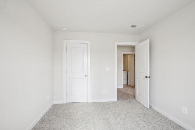 unfurnished bedroom with light carpet, visible vents, and baseboards