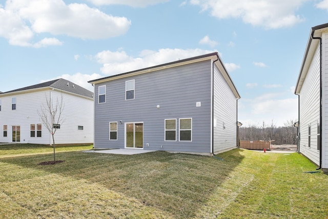 back of property with a lawn, a patio area, and a hot tub