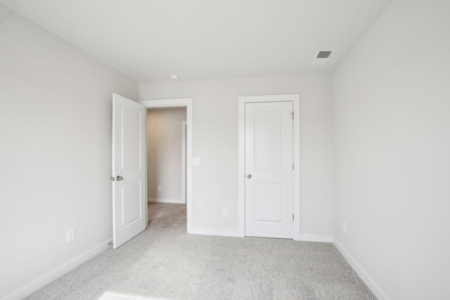 unfurnished bedroom featuring carpet, visible vents, and baseboards