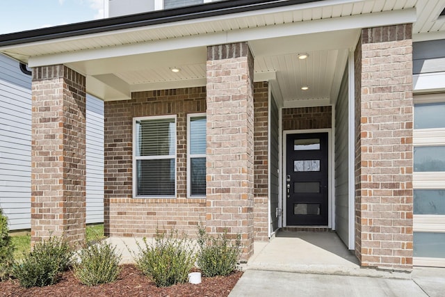 property entrance with a garage and brick siding