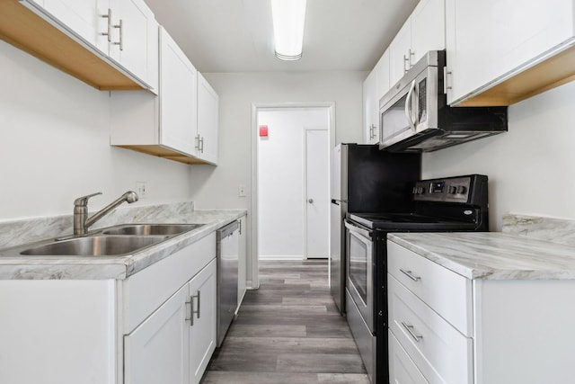 kitchen with dark hardwood / wood-style floors, sink, white cabinetry, and stainless steel appliances