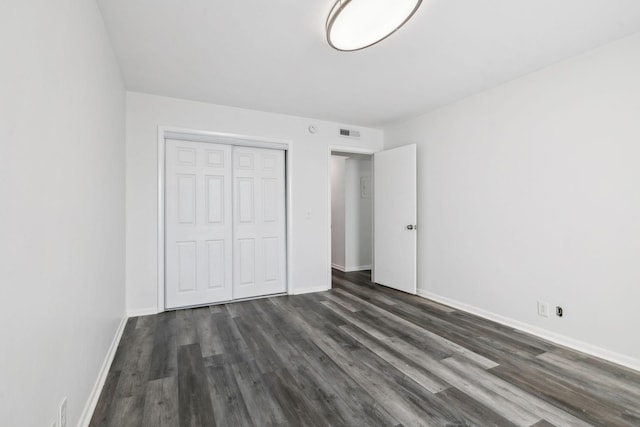 unfurnished bedroom featuring dark hardwood / wood-style floors and a closet