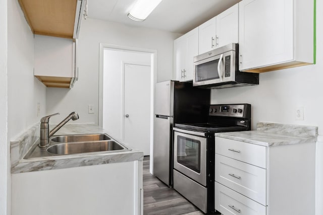 kitchen featuring white cabinets, appliances with stainless steel finishes, dark hardwood / wood-style floors, and sink