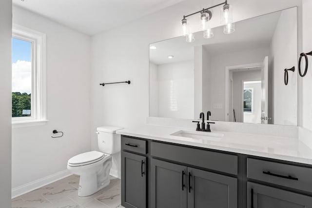 bathroom with a shower, vanity, toilet, and plenty of natural light