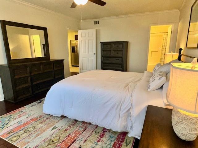 bedroom with ceiling fan, dark hardwood / wood-style flooring, and ornamental molding