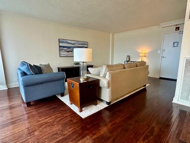 living room featuring a textured ceiling, dark hardwood / wood-style floors, and ornamental molding