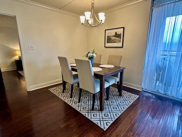 dining space with a chandelier, dark hardwood / wood-style flooring, and crown molding