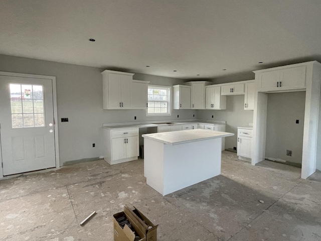 kitchen with a kitchen island, white cabinetry, and a wealth of natural light