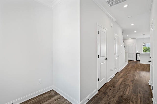 corridor featuring dark hardwood / wood-style flooring and crown molding