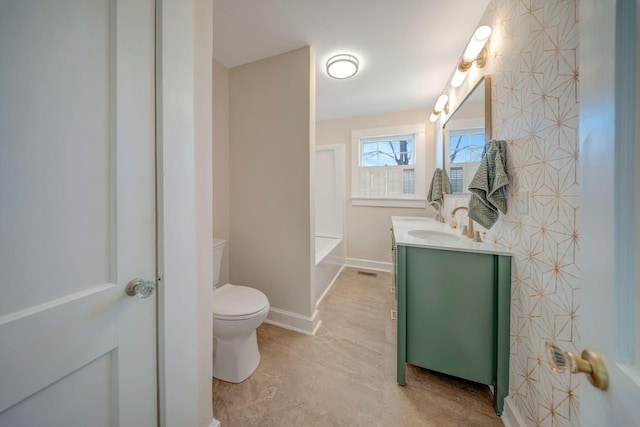 bathroom featuring a washtub, toilet, and vanity