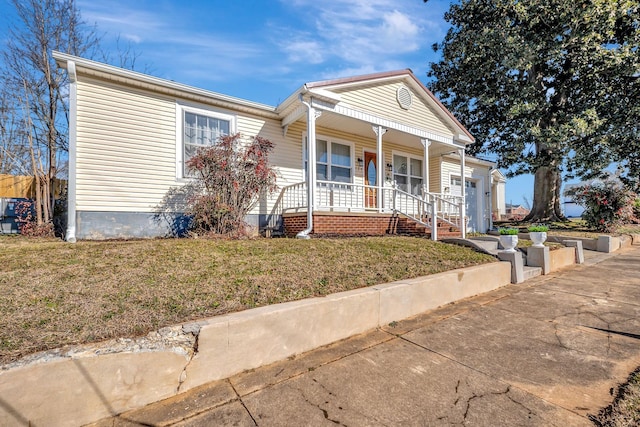 view of front facade featuring covered porch, a front lawn, and a garage