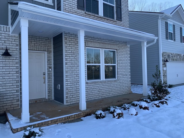 snow covered property entrance featuring covered porch