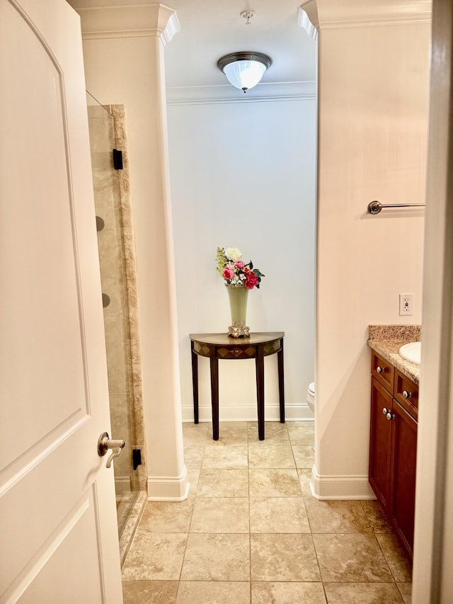 bathroom with toilet, vanity, a shower with shower door, and crown molding