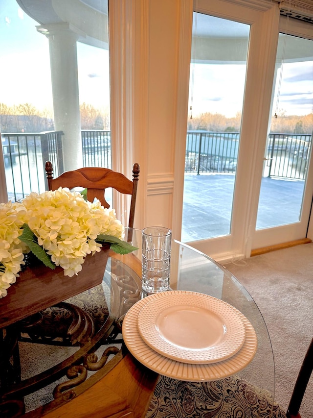 bedroom featuring carpet floors, access to outside, and a water view