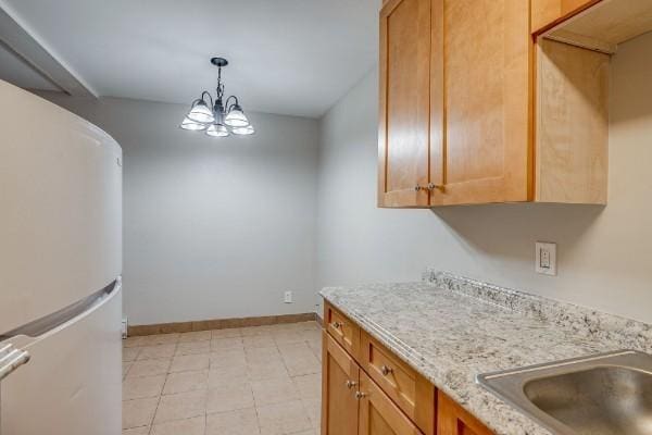 kitchen with white fridge, decorative light fixtures, and an inviting chandelier