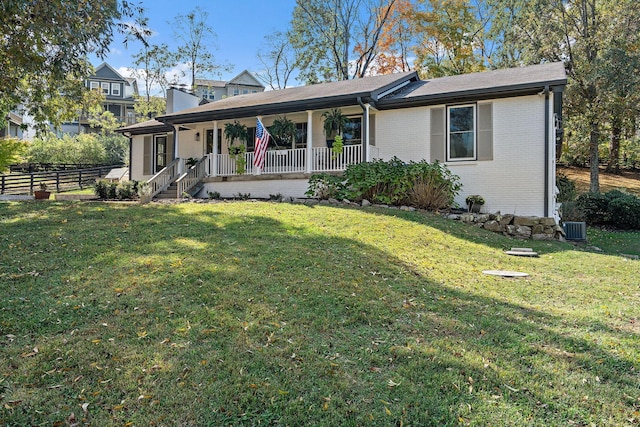 ranch-style house featuring a porch, a front yard, and central AC