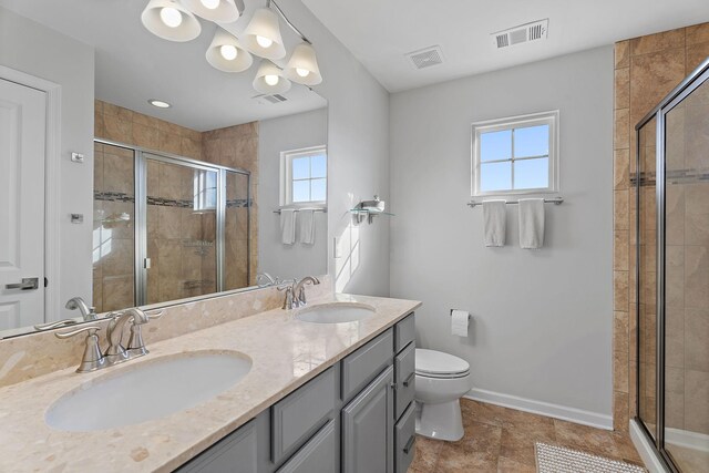 bathroom featuring plenty of natural light, toilet, and an enclosed shower