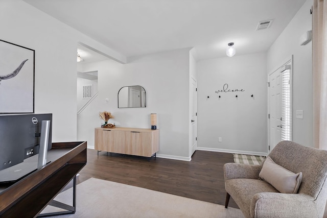 sitting room with dark hardwood / wood-style floors and beam ceiling