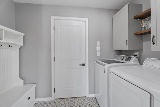 laundry area featuring light tile patterned floors, cabinets, and independent washer and dryer