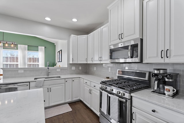 kitchen with white cabinets, sink, light stone countertops, dark hardwood / wood-style flooring, and stainless steel appliances