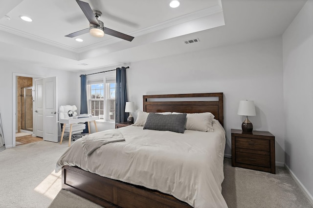 carpeted bedroom featuring a tray ceiling and ceiling fan