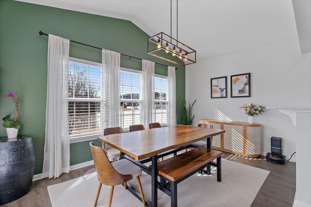 dining space featuring an inviting chandelier, dark hardwood / wood-style flooring, and vaulted ceiling