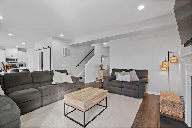 living room featuring a barn door and hardwood / wood-style flooring