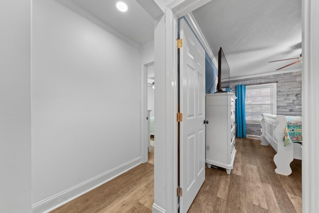 hall with light hardwood / wood-style flooring and ornamental molding