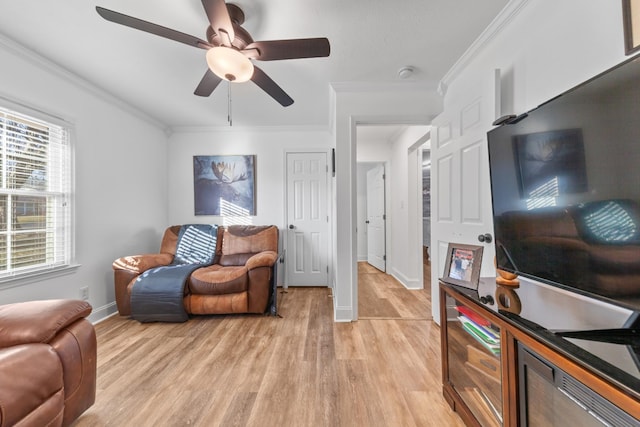 living room with ceiling fan, light wood-type flooring, and crown molding