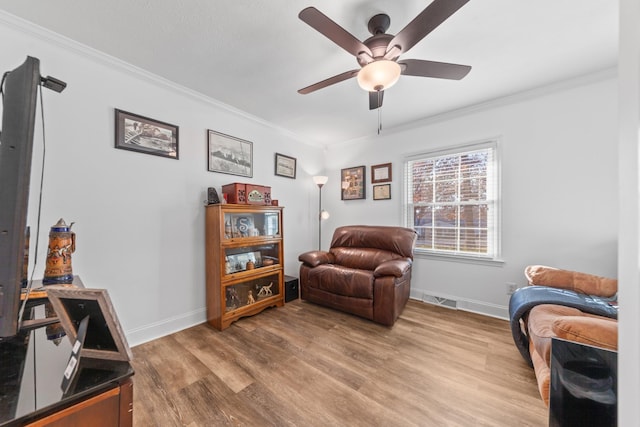 sitting room featuring ceiling fan, hardwood / wood-style floors, and ornamental molding