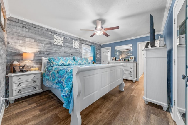 bedroom with ceiling fan, dark hardwood / wood-style floors, crown molding, wood walls, and a textured ceiling