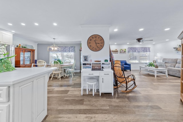 living room featuring light wood-type flooring, ceiling fan, and crown molding