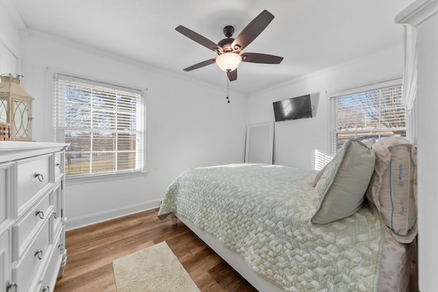 bedroom featuring ceiling fan, wood-type flooring, and ornamental molding