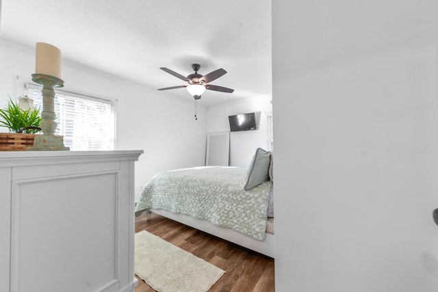 bedroom featuring crown molding, ceiling fan, and dark wood-type flooring