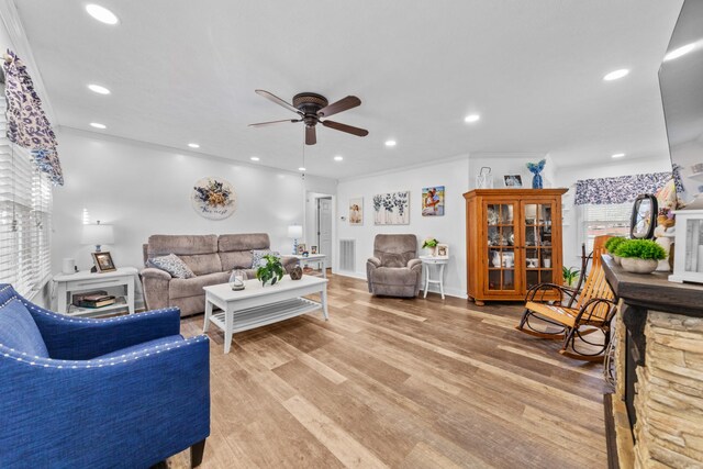 living room with ceiling fan, crown molding, and light hardwood / wood-style flooring