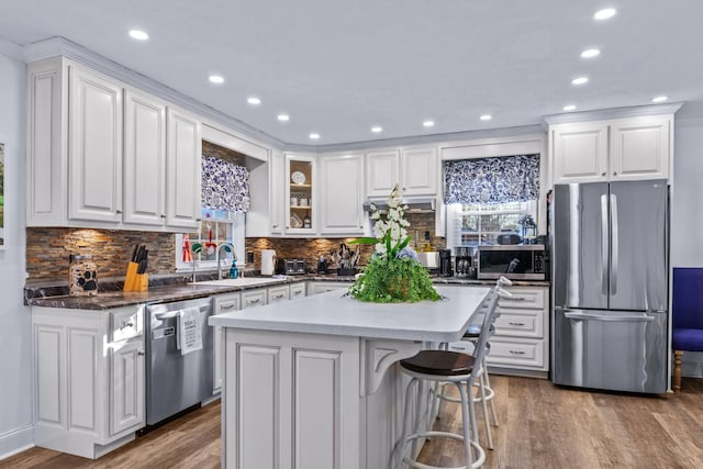 kitchen featuring sink, white cabinets, stainless steel appliances, and a kitchen island