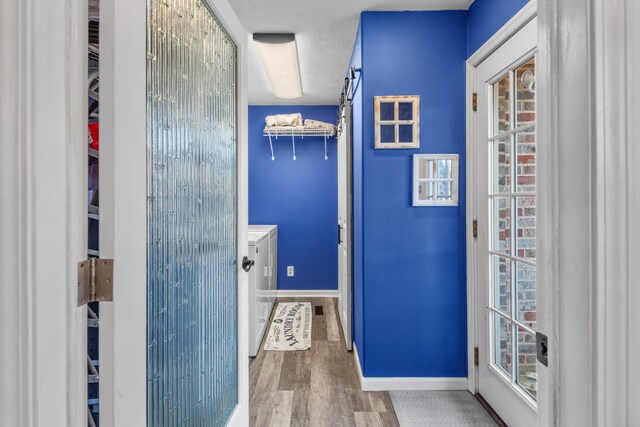 bathroom with wood-type flooring, a textured ceiling, and washer and clothes dryer