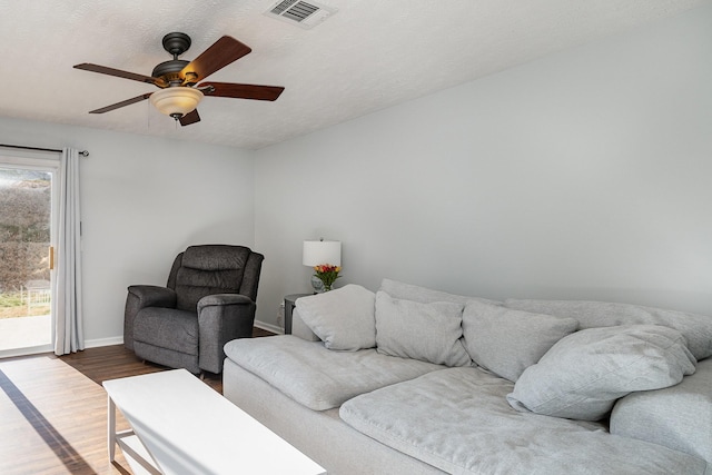 living room with hardwood / wood-style floors, a textured ceiling, plenty of natural light, and ceiling fan