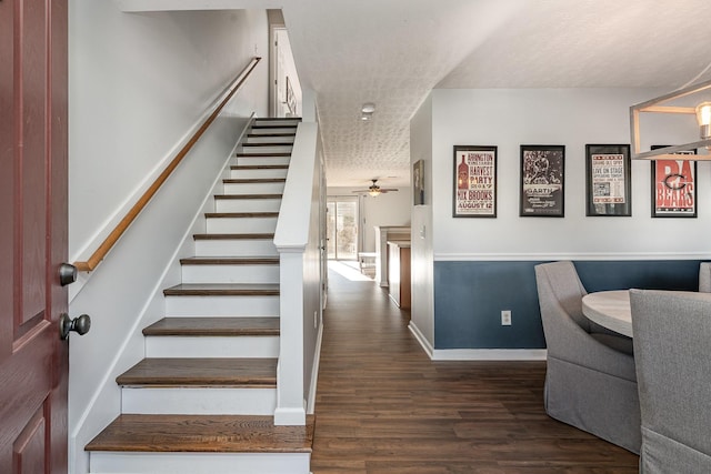 stairway with a textured ceiling, hardwood / wood-style flooring, and ceiling fan