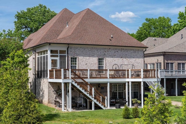 back of property with a lawn, a sunroom, a patio, and a deck