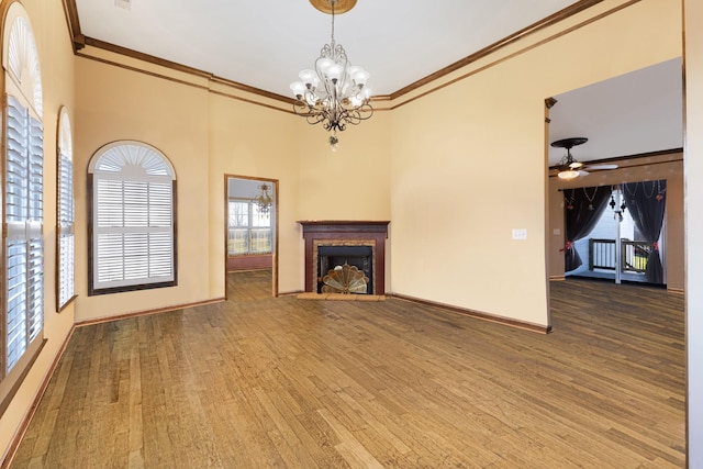 unfurnished living room featuring hardwood / wood-style floors, ceiling fan with notable chandelier, and crown molding