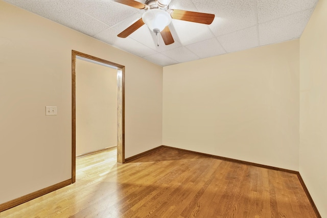 unfurnished room with a paneled ceiling, ceiling fan, and light wood-type flooring