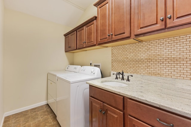 clothes washing area featuring cabinets, dark tile patterned floors, washer and clothes dryer, and sink