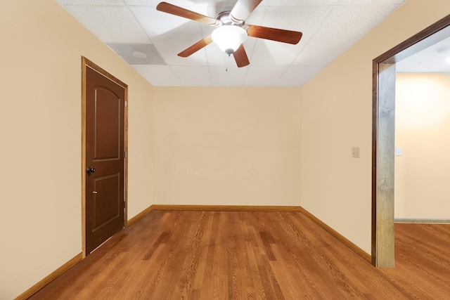 empty room with light wood-type flooring, a paneled ceiling, and ceiling fan