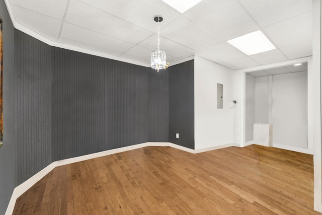 unfurnished room with wood-type flooring and a drop ceiling