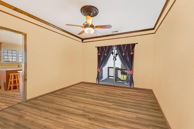 spare room with hardwood / wood-style flooring, ceiling fan, and crown molding