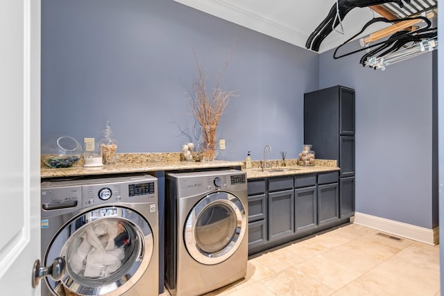 washroom with sink, cabinets, light tile patterned floors, washing machine and clothes dryer, and crown molding